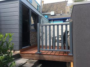 una terrazza in legno con sedia sul balcone di Centre beach lodge (2) a Zandvoort