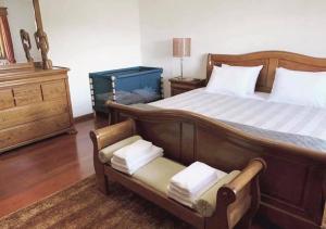 ポンテ・デ・リマにあるCasa da presaのベッドルーム1室(木製ベッド1台、椅子、ドレッサー付)