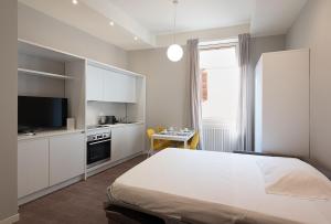 una camera con letto e TV e una cucina di Good night Romeo - Eleganti Dimore a Verona