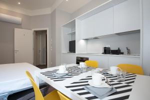 una sala da pranzo con un tavolo bianco e sedie gialle di Good night Romeo - Eleganti Dimore a Verona Altre 27 foto