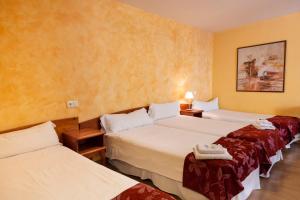 una camera d'albergo con tre posti letto di Hostal Restaurante Puerta del Alcázar ad Ávila