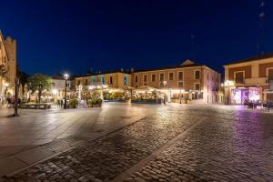 eine leere Stadtstraße in der Nacht mit Gebäuden in der Unterkunft Hostal Restaurante Puerta del Alcázar in Avila