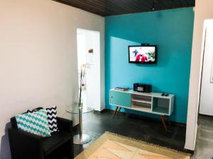 un salon avec une télévision sur un mur bleu dans l'établissement Espaço Sorrentino's, à Itupeva