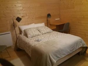 ein Schlafzimmer mit einem Bett und einem Schreibtisch mit einer Lampe in der Unterkunft Julio César Poligny Jura in Poligny