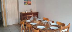 une table en bois avec des assiettes et des verres dans l'établissement Julio César Poligny Jura, à Poligny