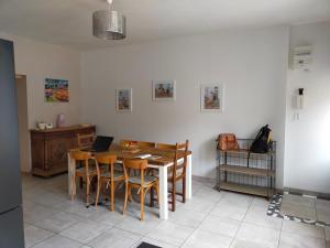 a kitchen with a table with chairs and a laptop on it at Julio César Poligny Jura in Poligny