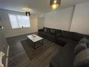 a living room with a couch and a table at NEW Luxurious Modern Large 3 Bed House - Sleeps Up to 10 Guests - Sky Ultra HD, Sky Movies, Netflix, Disney Plus in Mansfield