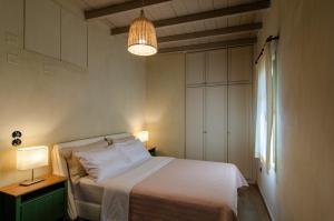 a bedroom with a white bed and a lamp at MyYellowHome in Ermoupoli