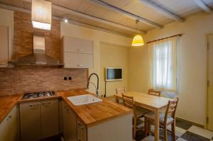 eine Küche und ein Esszimmer mit einem Tisch und einem Waschbecken in der Unterkunft MyYellowHome in Ermoupoli