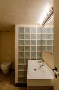 ein Badezimmer mit einem Waschbecken, einem WC und einem Spiegel in der Unterkunft MyYellowHome in Ermoupoli
