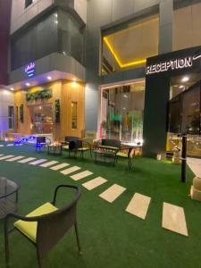 a building with tables and chairs on the grass at Desert Rose in Hail