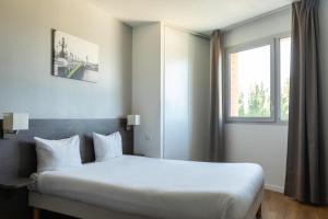 um quarto de hotel com uma cama grande e uma janela em Aparthotel Adagio Access Nogent sur Marne em Nogent-sur-Marne