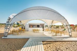 a tent on the beach with tables and chairs at Hotel DelMarInn All inclusive in Vityazevo