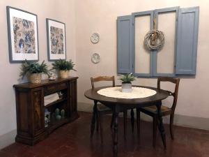 ein Esszimmer mit einem Tisch und 2 Stühlen in der Unterkunft Camera Suite Romantica con Giardino in Dimora Storica - B&B Palazzo Robicci in Castiglion Fiorentino