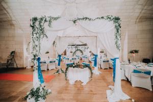 a wedding altar with white tables and flowers at Les Chambres de l'Abbaye in Saintes