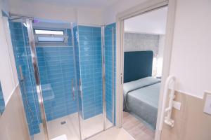 mała łazienka z przeszkloną kabiną prysznicową i łóżkiem w obiekcie HOTEL ADRIA BEACH w Rimini +37 zdjęć