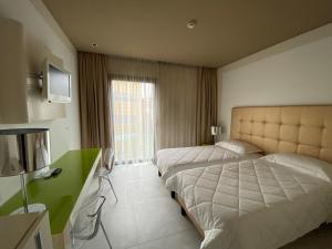 a hotel room with two beds and a television at One Hotel & Restaurant in Dalmine