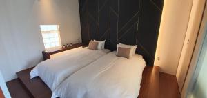 2 camas blancas en una habitación con ventana en Wellis Villa HANARE, en Awaji