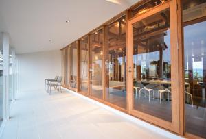 Habitación con puertas de cristal, mesa y sillas. en Wellis Villa HANARE en Awaji