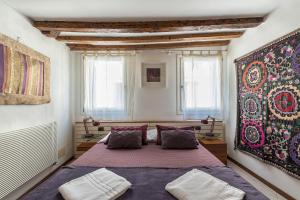 um quarto com uma cama e um grande tapete na parede em PICCOLO - Cozy studio in the heart of authentic Venice em Veneza