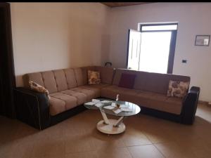 a living room with a brown couch and a table at Private House Durres in Durrës