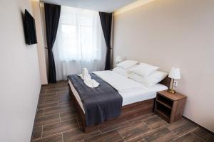 Schlafzimmer mit einem Bett mit weißer Bettwäsche und einem Fenster in der Unterkunft MP hotel in Znojmo
