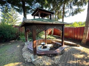 a wooden gazebo with a table in a yard at Alfrédó Delux Apartman Nyíregyháza-Sóstófürdő in Nyíregyháza