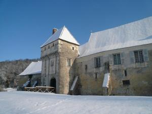 een oud stenen gebouw met sneeuw op de grond bij Chateau-monastère de La Corroirie in Montrésor