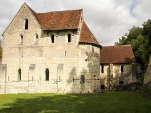 un ancien bâtiment en pierre avec un toit sur un champ dans l'établissement Chateau-monastère de La Corroirie, à Montrésor