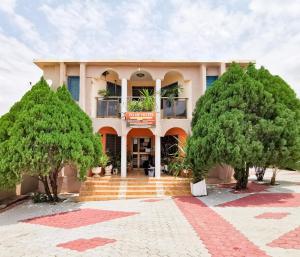 a building with trees in front of it at To Be Hotel in Kumasi