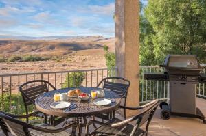 a table and chairs on a balcony with a grill at WorldMark St. George in St. George