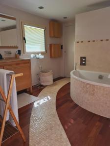 bagno con vasca e lavandino di Maison de vacances Daumeray a Daumeray