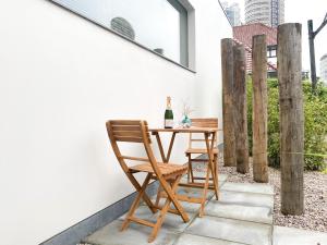 einen Tisch und einen Stuhl auf einer Terrasse mit einer Flasche Wein in der Unterkunft Studio KA06 Het Strandhuis in Vlissingen