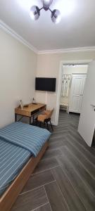 a bedroom with a bed and a desk and a table at White rezidence in Curtea de Argeş