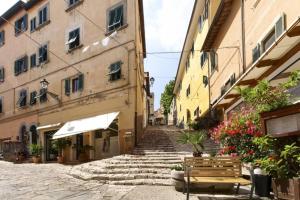 una strada in una città vecchia con panchine ed edifici di La Ganza suite apartment Visit the most charming sea of Tuscany a Portoferraio