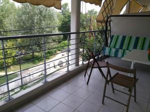 a balcony with a chair and a window with a view at Larisa, Park view apartment in Larisa
