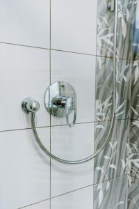 a shower with a hose on a tiled wall at Prachárna Park Hotel Olomouc in Olomouc