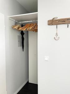 a room with white walls and a closet with wooden racks at Ferienwohnung Yachthafen-Fördeblick in Glücksburg