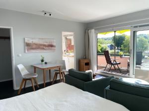 a bedroom with a bed and a table and chairs at Ferienwohnung Yachthafen-Fördeblick in Glücksburg