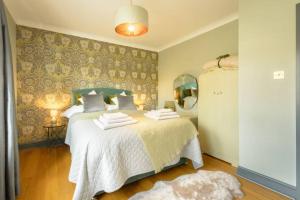 1 dormitorio con 1 cama con sábanas blancas y espejo en Entire cottage in the beautiful Calder Valley en Halifax