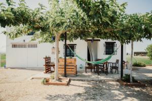 a backyard with a hammock and a house at La Caseta de Panisello in Deltebre