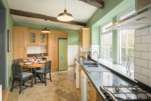 cocina con mesa y nevera verde en Entire cottage in the beautiful Calder Valley en Halifax