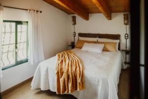 Schlafzimmer mit einem Bett mit weißer Bettwäsche und einem Fenster in der Unterkunft La Caseta de Panisello in Deltebre