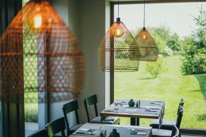a dining room with tables and chairs and a large window at Prachárna Park Hotel Olomouc in Olomouc