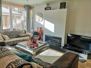 - un salon avec un canapé, une télévision et une table dans l'établissement Home & garden suites center Granada, à Grenade