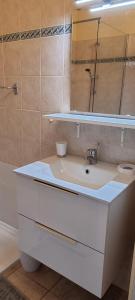 bagno con lavandino bianco e specchio di Résidence Les Thermes de Vernet-les-Bains a Vernet-les-Bains