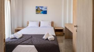a bedroom with a bed with two pillows on it at Mythic Villas in Epanomi