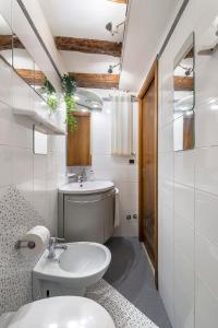 uma casa de banho branca com um lavatório e um WC em PICCOLO - Cozy studio in the heart of authentic Venice em Veneza