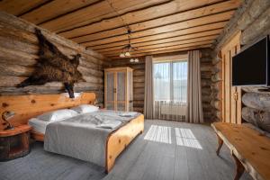 a bedroom with a bed in a log cabin at База отдыха "Черные камни" Коттеджи in Ruskeala