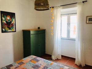 Campinho的住宿－Casa Campinho，一间卧室设有绿色的橱柜和窗户。